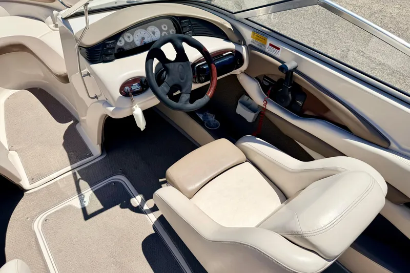 Slide: The Image of Interior of a 2002 Larson LXi 210 boat, featuring steering wheel and dashboard controls. - 31