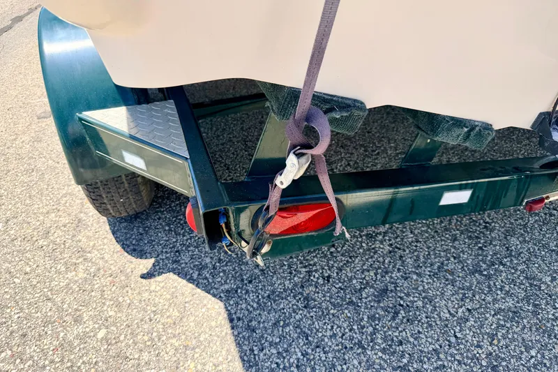 Slide: The Image of Trailer hitch of a 2002 Larson LXi 210 boat on asphalt surface. - 67