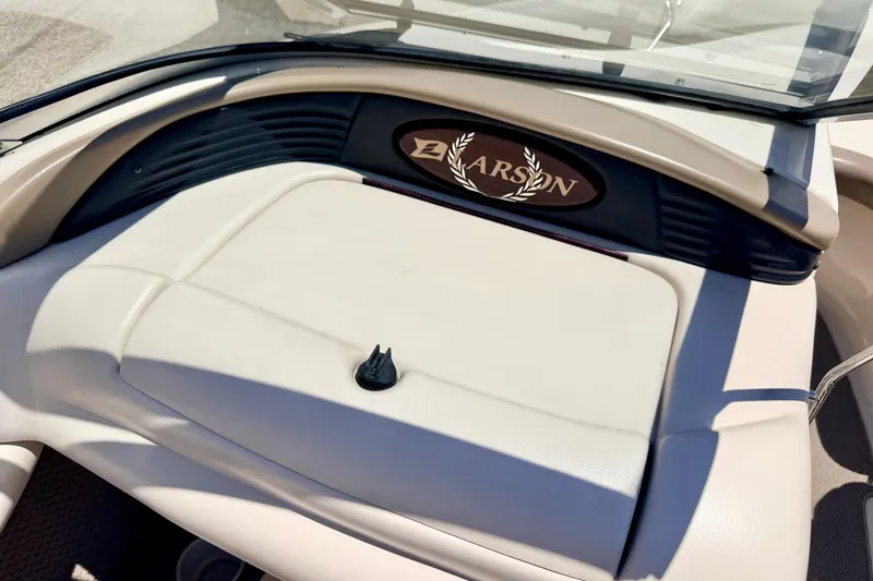 Slide: The Image of 2002 Larson LXi 210 boat dashboard with logo and beige interior. - 44