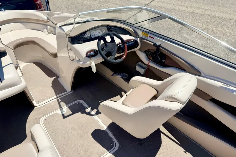 Slide: The Image of Interior of a 2002 Larson LXi 210 boat, featuring steering wheel and seating. - 59