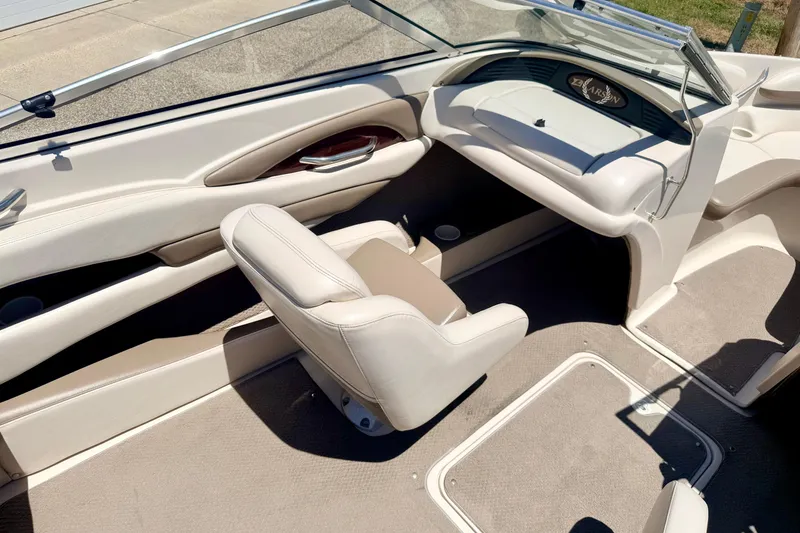 Slide: The Image of Interior of a 2002 Larson LXi 210 boat, featuring beige seating and dashboard. - 60