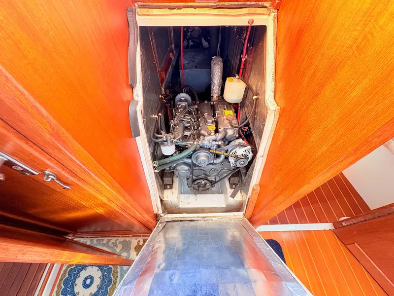 Slide: The Image of The engine compartment of a 1994 Catalina 42 shows a well-maintained engine with wooden walls. - 42