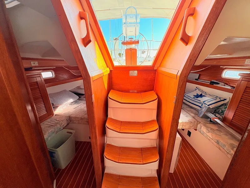 Slide: The Image of Interior of a 1994 Catalina 42 with wooden steps and sleeping cabins. - 37