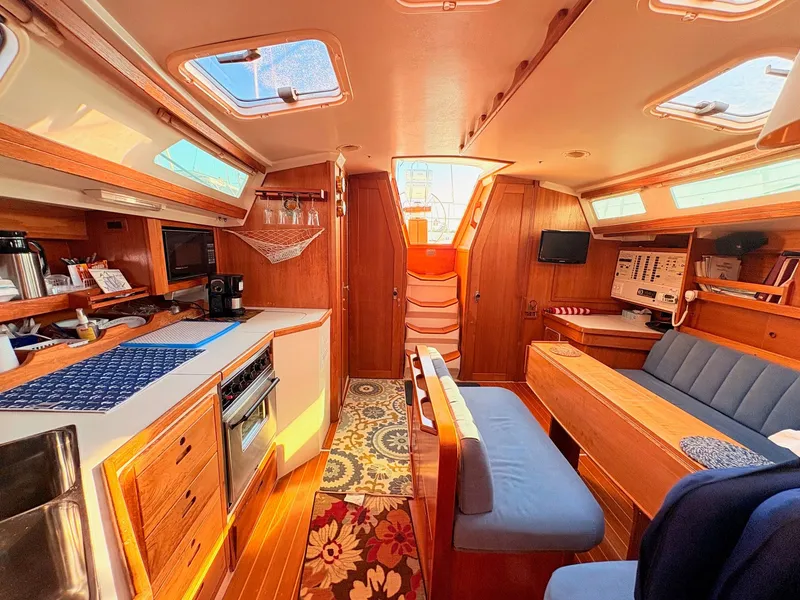 Slide: The Image of Interior of a 1994 Catalina 42 with wood finishes, blue upholstery, and a well-equipped galley. - 31
