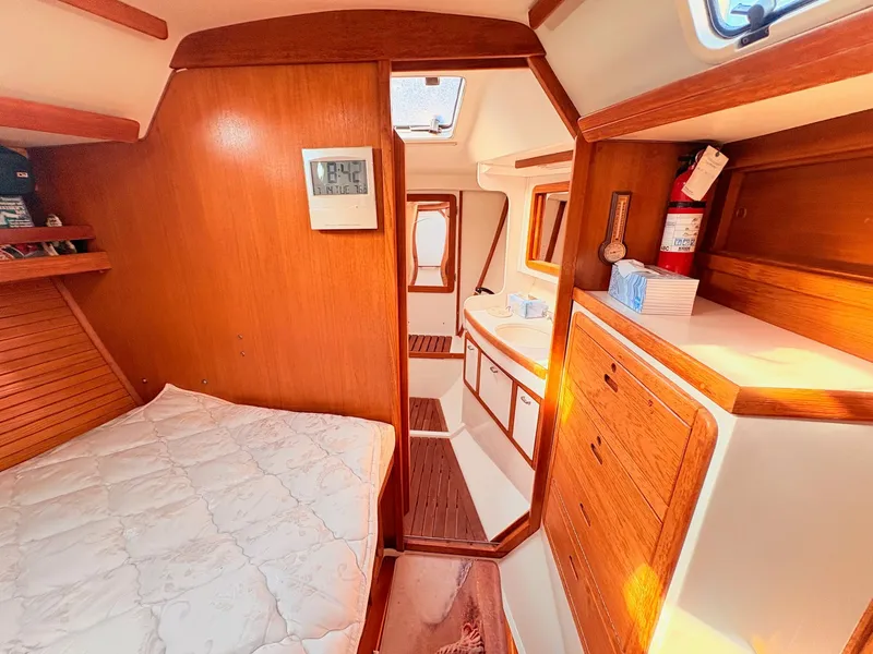 Slide: The Image of Interior of a 1994 Catalina 42 with wood finish, bed, cabinets, and a small window. - 24