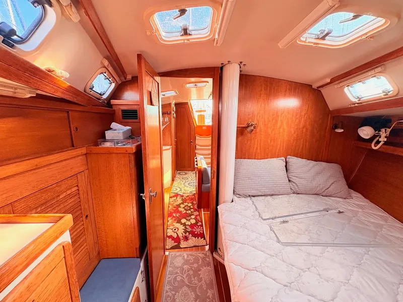 Slide: The Image of Interior of a 1994 Catalina 42 with a cozy bed and wooden furnishings. - 30