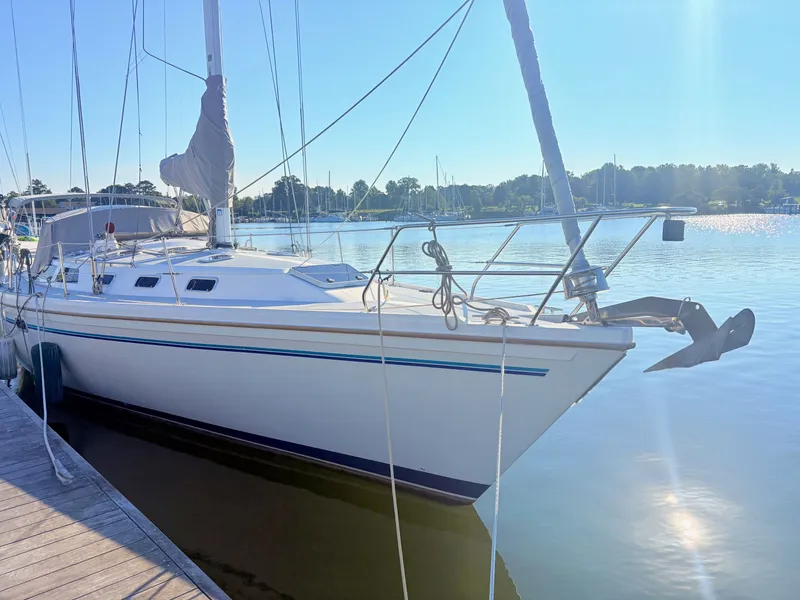 Slide: The Image of A white sailboat docked at a calm pier. The sky is clear and sunny. - 1