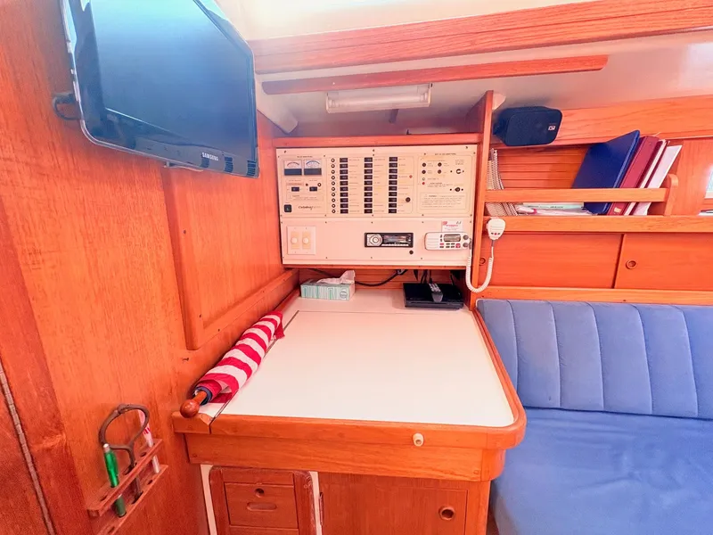 Slide: The Image of Interior of a 1994 Catalina 42 featuring a navigation area and blue seating. - 32