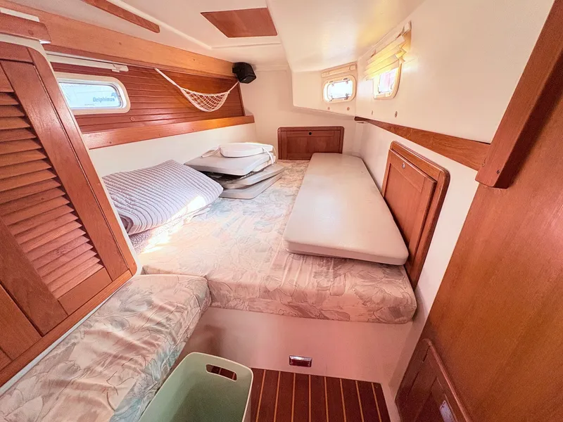 Slide: The Image of Interior of a 1994 Catalina 42 featuring a cozy sleeping area with wooden accents. - 38