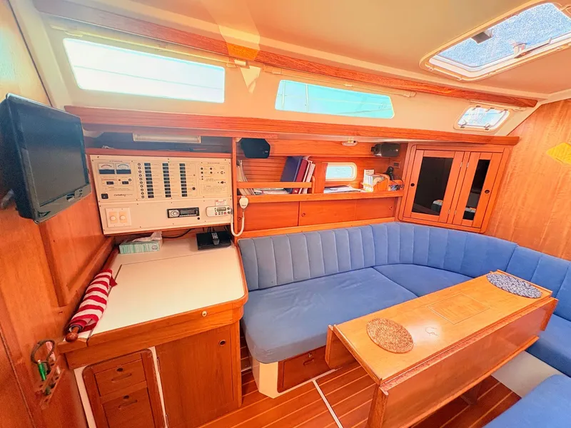 Slide: The Image of The interior of a 1994 Catalina 42 features a cozy seating area with blue cushions. - 20