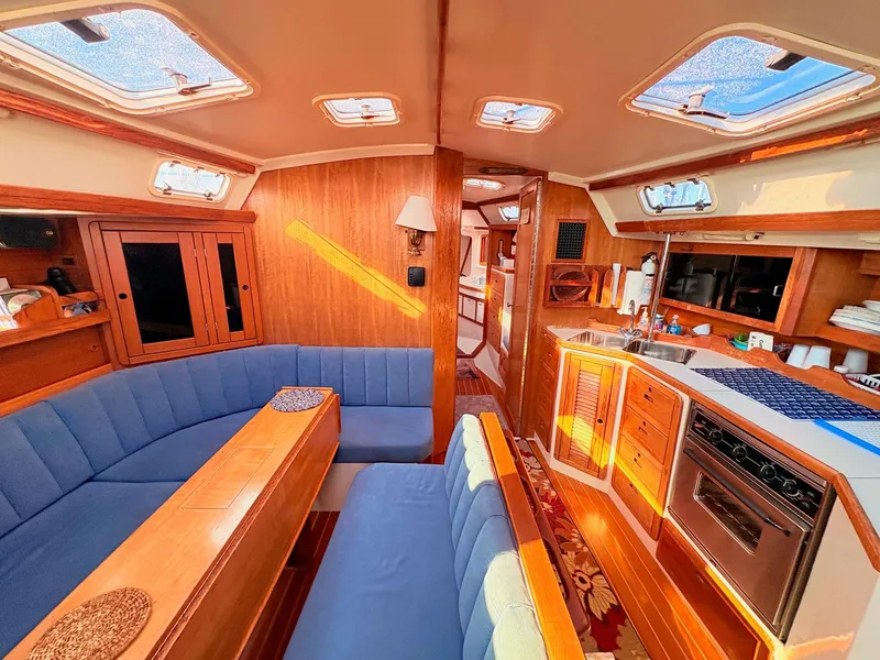 Slide: The Image of Interior of a 1994 Catalina 42 with blue upholstery and wooden furnishings. - 19