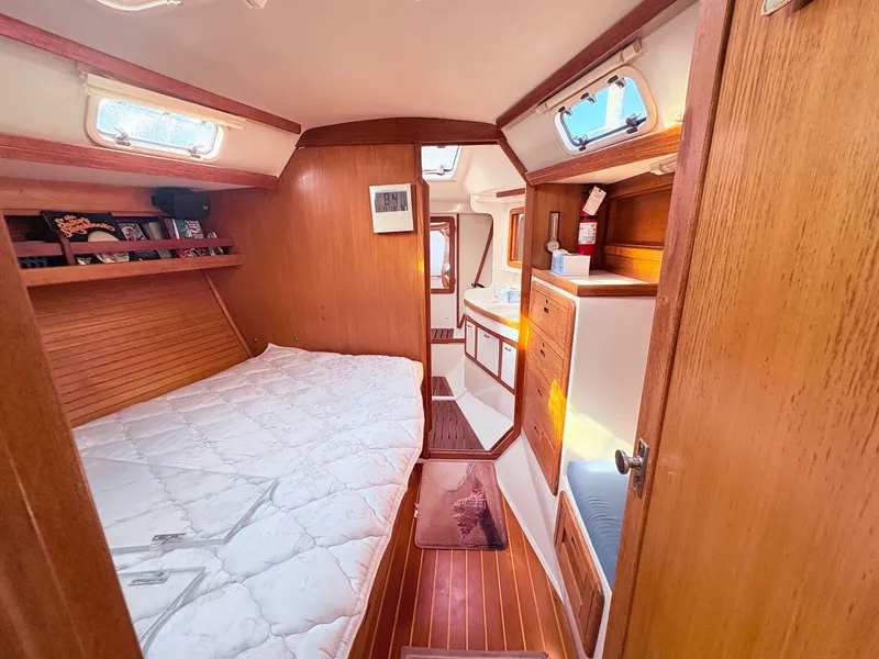 Slide: The Image of Interior of a 1994 Catalina 42 with wood paneling and a cozy bed. - 22