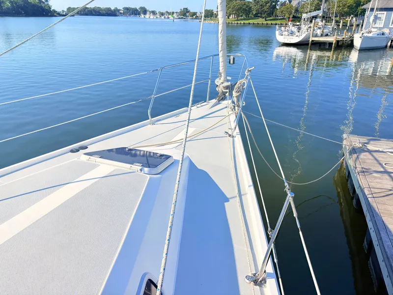 Slide: The Image of The deck of a 1994 Catalina 42 rests calmly at the dock, surrounded by tranquil water. - 12