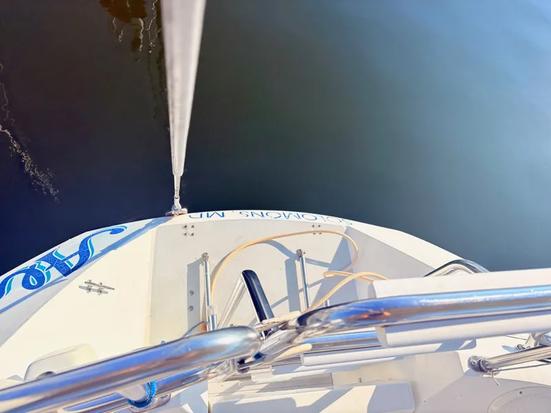 Slide: The Image of Top view of a white sailboat's stern with railing and water in the background. - 6
