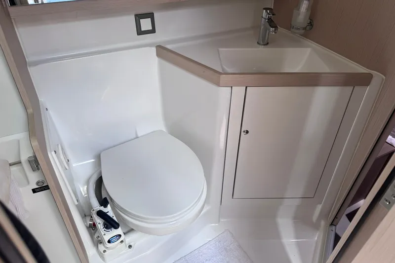 Slide: The Image of Bathroom interior of 2022 Beneteau Oceanis 46.1 yacht, featuring a compact toilet and sink. - 33