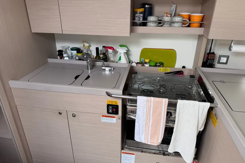 Slide: The Image of Modern kitchen in 2022 Beneteau Oceanis 46.1 yacht with stove, sink, and storage. - 46