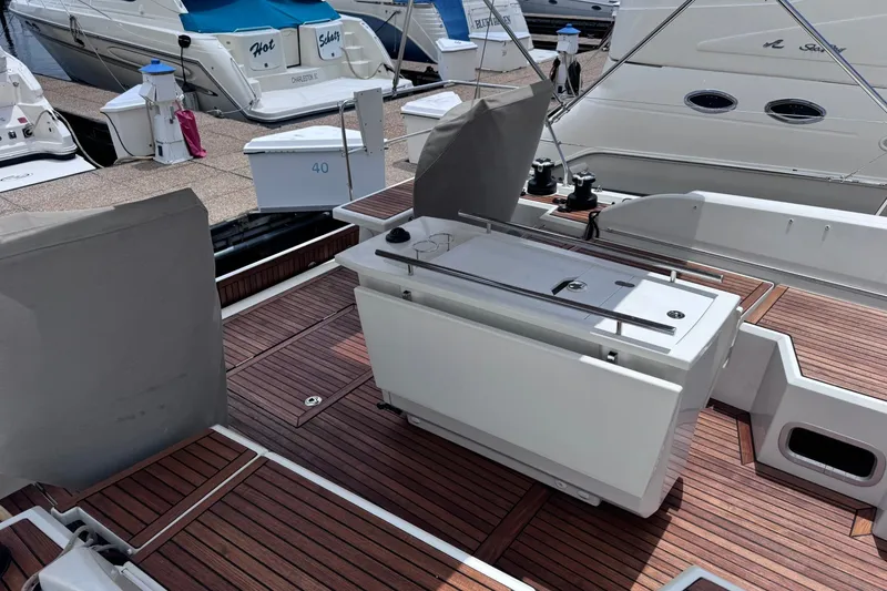 Slide: The Image of 2022 Beneteau Oceanis 46.1 yacht deck with wooden flooring and covered seating area. - 9