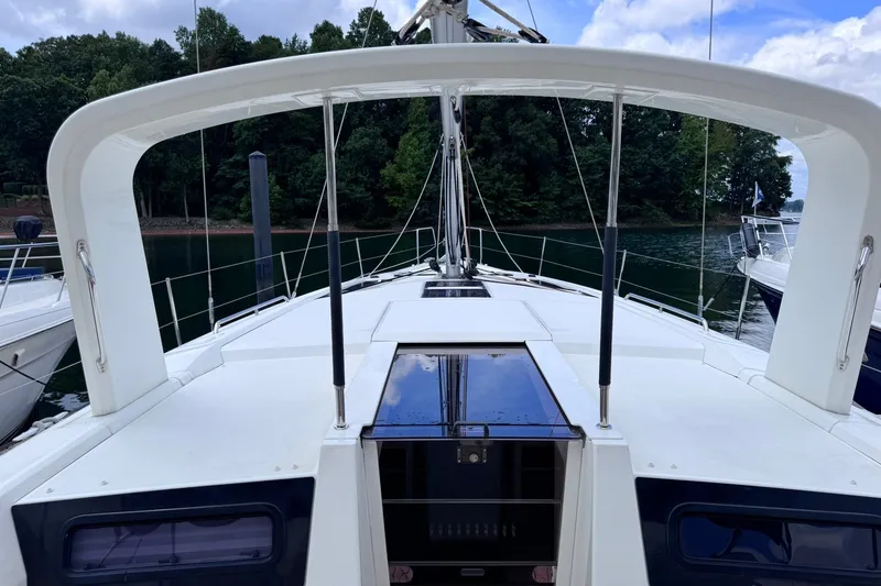 Slide: The Image of Beneteau Oceanis 46.1 sailboat deck, 2022 model, docked by lush green shoreline. - 15