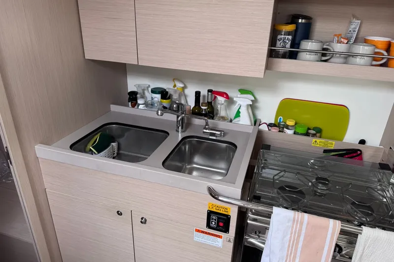 Slide: The Image of Modern kitchen area in a 2022 Beneteau Oceanis 46.1 yacht, featuring a dual sink and stove. - 48