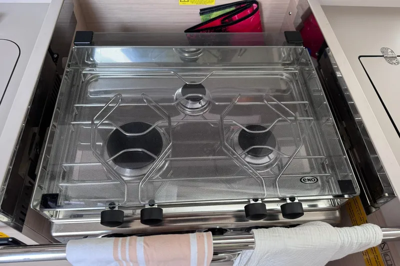 Slide: The Image of Stove in 2022 Beneteau Oceanis 46.1 yacht kitchen, featuring three burners and protective cover. - 45