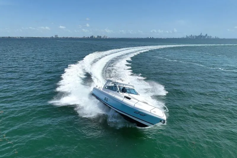 Slide: The Image of Intrepid 430 Sport Yacht 2017 cruising on open water with city skyline in background. - 8