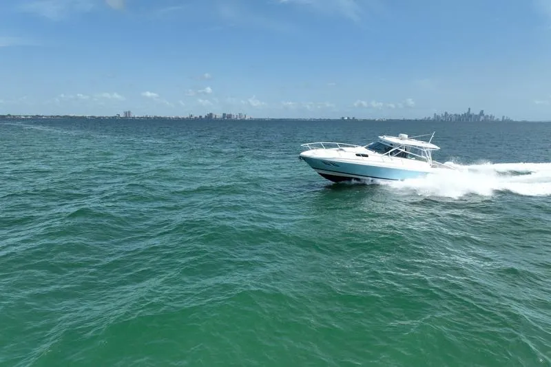 Slide: The Image of 2017 Intrepid 430 Sport Yacht cruising on open water with city skyline in background. - 15