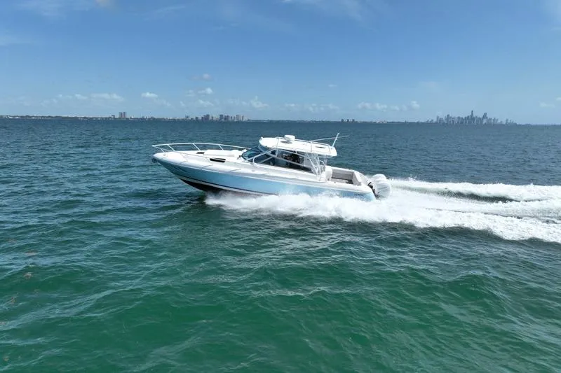 Slide: The Image of Intrepid 430 Sport Yacht 2017 cruising on open water with city skyline in background. - 11
