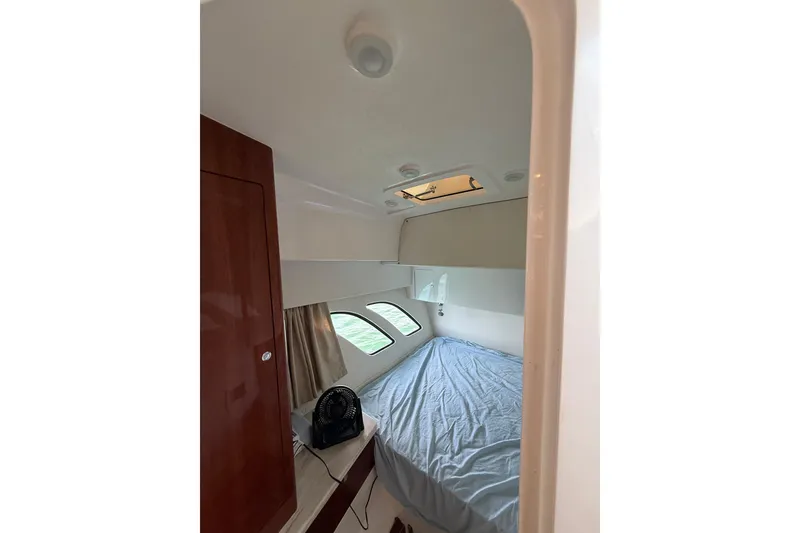 Slide: The Image of Cozy cabin interior of 2017 Intrepid 430 Sport Yacht with bed and porthole windows. - 25