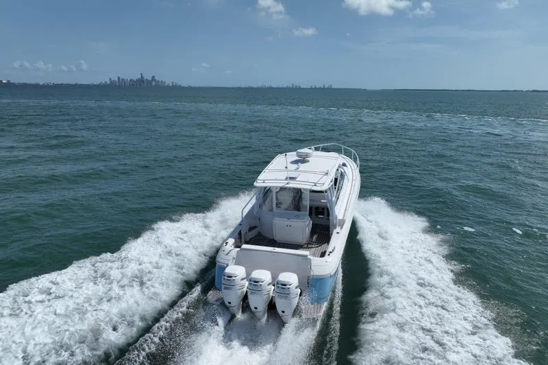 Slide: The Image of 2017 Intrepid 430 Sport Yacht cruising on open water with city skyline in background. - 14