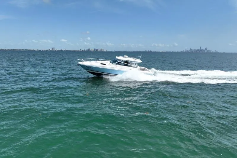 Slide: The Image of 2017 Intrepid 430 Sport Yacht cruising on open water with city skyline in background. - 17