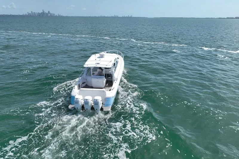 Slide: The Image of 2017 Intrepid 430 Sport Yacht cruising on open water with city skyline in background. - 10