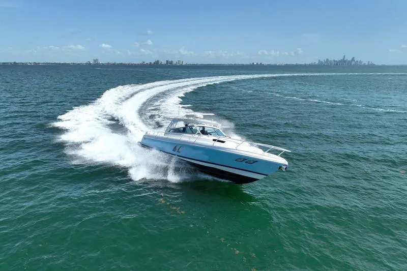 Slide: The Image of Intrepid 430 Sport Yacht 2017 cruising swiftly on open water with city skyline backdrop. - 4