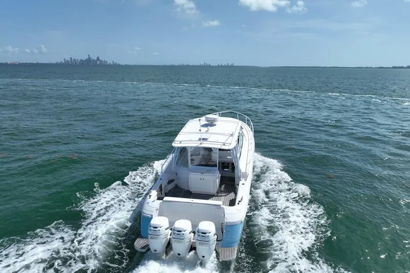 Slide: The Image of 2017 Intrepid 430 Sport Yacht cruising on open water with city skyline in background. - 5