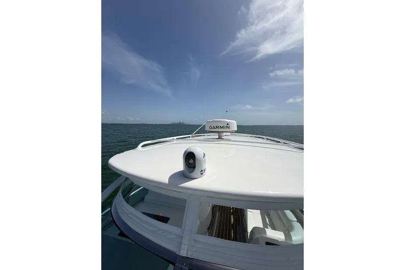 Slide: The Image of 2017 Intrepid 430 Sport Yacht on open water, featuring Garmin equipment under a clear sky. - 60
