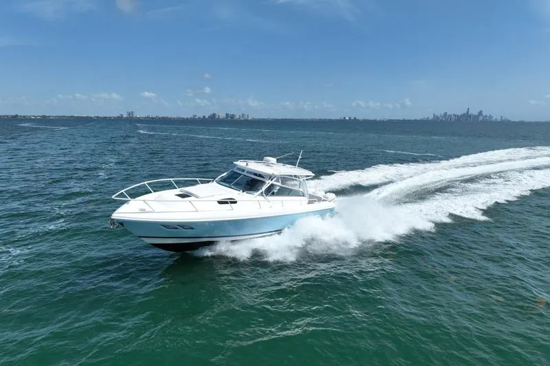 Slide: The Image of Intrepid 430 Sport Yacht 2017 cruising on open water with city skyline in background. - 9