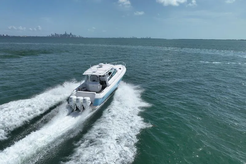 Slide: The Image of 2017 Intrepid 430 Sport Yacht cruising on open water with city skyline in background. - 13