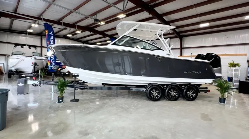 The Image of A 2024 Blackfin 272 DC boat on a trailer inside a showroom. - 0