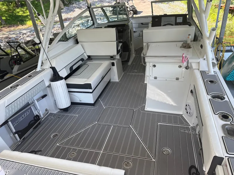 Slide: The Image of The image shows the spacious cockpit of a 2024 Blackfin 272 DC boat with white upholstery and gray flooring. - 3