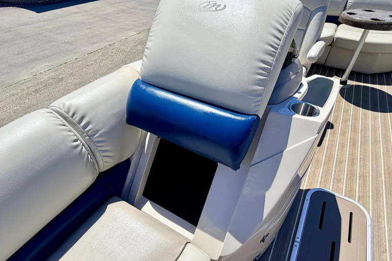 Slide: The Image of 2015 Manitou 25 SES BENCH boat interior with cushioned seating and cup holder. - 32
