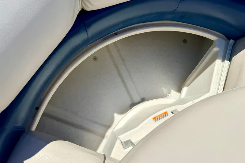 Slide: The Image of 2015 Manitou 25 SES BENCH boat storage compartment with blue and white seating. - 59
