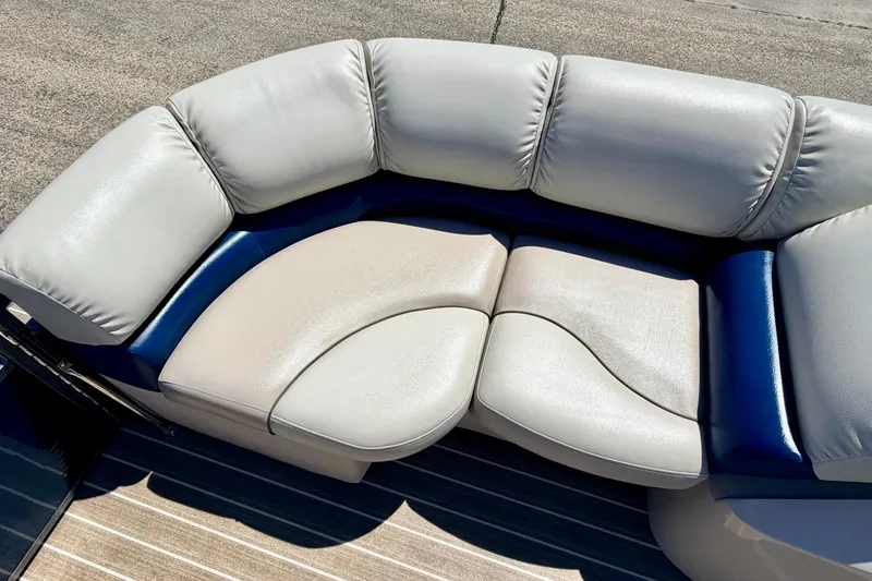 Slide: The Image of Luxurious seating on 2015 Manitou 25 SES BENCH pontoon boat, featuring plush, curved upholstery. - 28