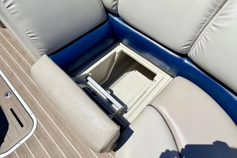 Slide: The Image of 2015 Manitou 25 SES BENCH boat seat storage compartment, open with visible interior. - 38