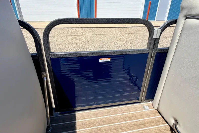 Slide: The Image of 2015 Manitou 25 SES BENCH boat interior with blue gate and wooden flooring. - 81