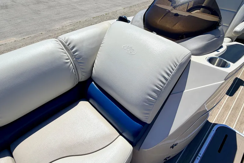 Slide: The Image of 2015 Manitou 25 SES BENCH boat interior with plush seating and cup holder. - 34