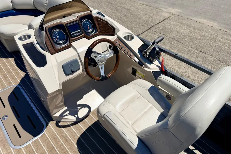Slide: The Image of 2015 Manitou 25 SES BENCH boat dashboard with steering wheel and controls. - 45
