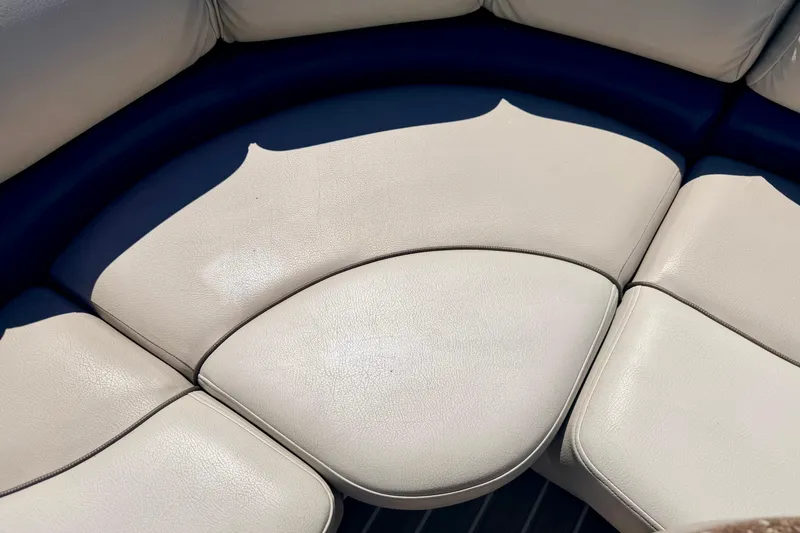 Slide: The Image of 2015 Manitou 25 SES BENCH boat seating with cream upholstery in sunlight. - 58