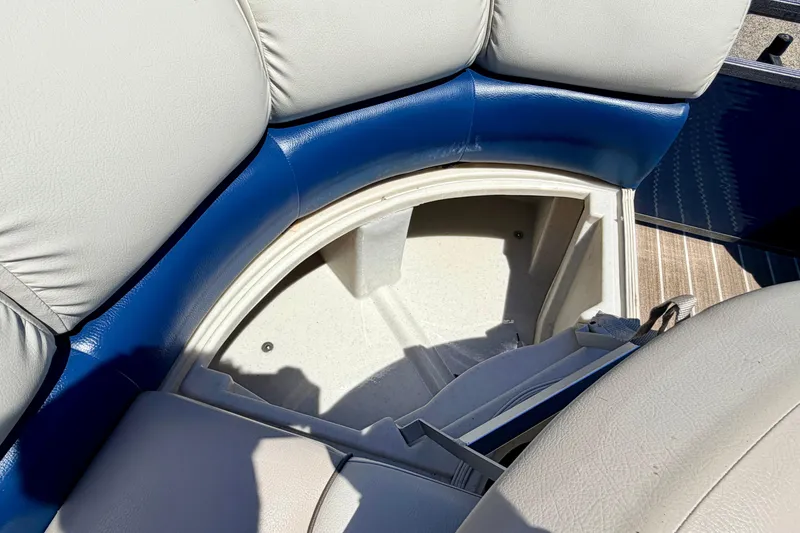 Slide: The Image of 2015 Manitou 25 SES BENCH boat seat storage compartment, featuring blue and white upholstery. - 36