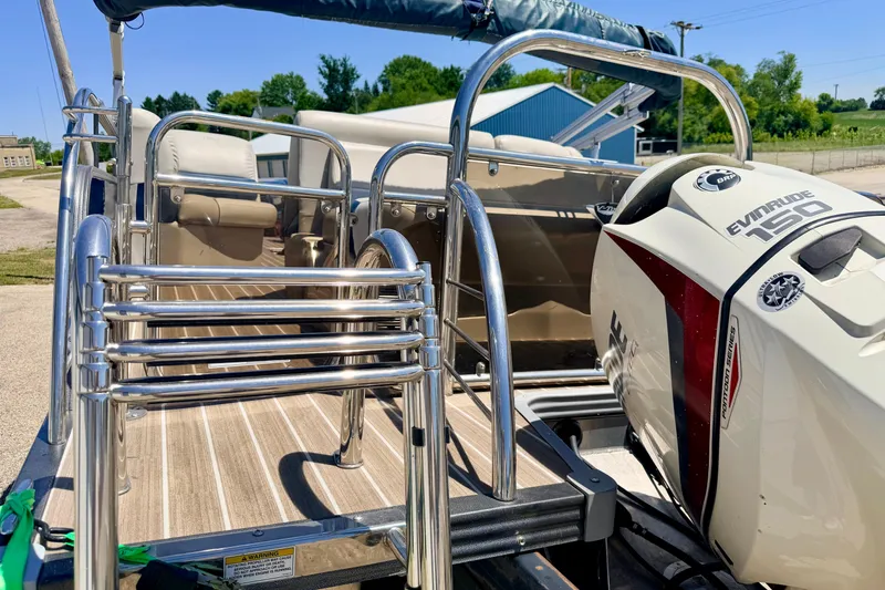 Slide: The Image of 2015 Manitou 25 SES BENCH pontoon boat with Evinrude 150 engine, docked outdoors. - 22