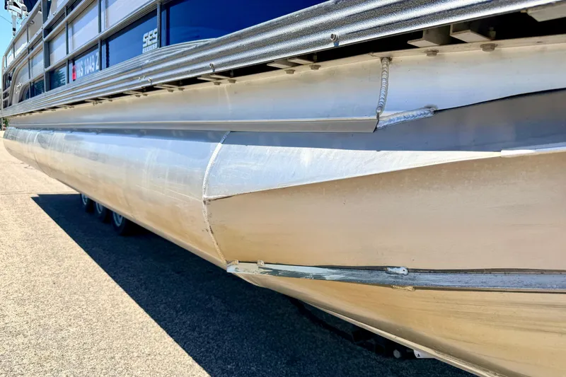 Slide: The Image of 2015 Manitou 25 SES BENCH pontoon boat, close-up of aluminum hull and side details. - 92