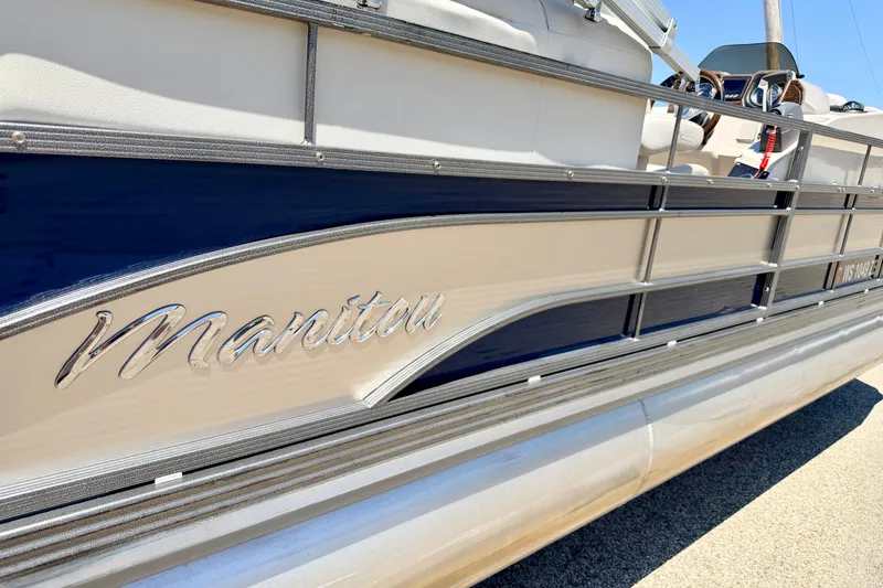 Slide: The Image of 2015 Manitou 25 SES BENCH pontoon boat with sleek design and chrome logo. - 16